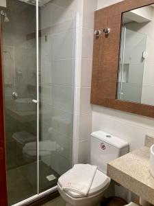 een badkamer met een toilet en een glazen douche bij Aruá Pousada Boutique in Torres