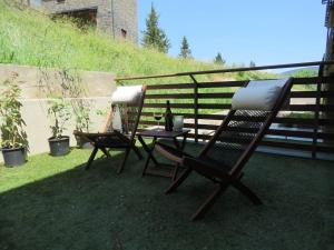 two rocking chairs and a table on a patio at Disfruta de LaCerdanya en "Casa Egipcia" in La Molina