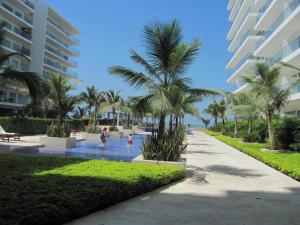 una piscina resort con palmeras y gente en ella en Apartamento Morros Ultra 511, en Cartagena de Indias