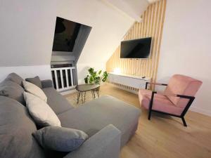 uma sala de estar com um sofá e uma cadeira em La Suite ALOHA, Elegant & Cosy em Beauvais