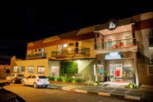 a building with a car parked in front of it at Hotel Almanara in Pirapòzinho