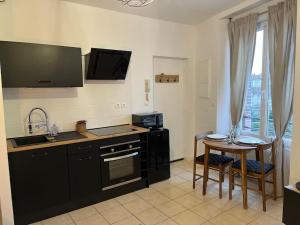 a kitchen with a sink and a table with chairs at Le Clos in Épernay