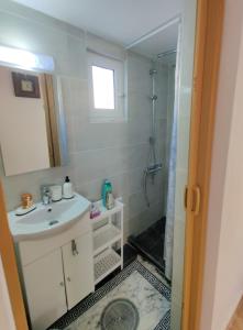 a bathroom with a sink and a shower at Lakena Sunset View Villa in Menetaí