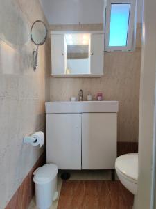 a white bathroom with a sink and a toilet at Lakena Sunset View Villa in Menetaí