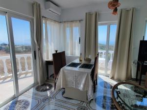 Habitación con mesa y balcón con ventanas. en Lakena Sunset View Villa, en Menetaí