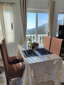 una mesa de comedor con un mantel blanco y sillas en Lakena Sunset View Villa, en Menetaí
