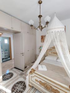 a bedroom with a canopy bed with a chandelier at Lakena Sunset View Villa in Menetaí