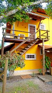a yellow house with a staircase in front of it at Casa temporada na praia Joia do Atlântico - Ilhéus - Ba in Ilhéus
