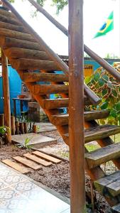 a wooden stairs in a garden with a table at Casa temporada na praia Joia do Atlântico - Ilhéus - Ba in Ilhéus