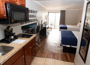 a small hotel room with a bed and a kitchen at Aqua Beach Inn in Myrtle Beach