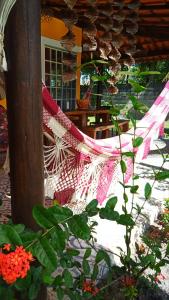 a red and white hammock hanging from a porch at Casa temporada na praia Joia do Atlântico - Ilhéus - Ba in Ilhéus