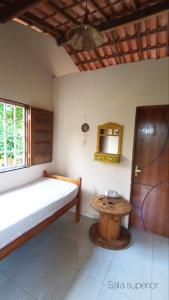 a bedroom with a bed and a table at Casa temporada na praia Joia do Atlântico - Ilhéus - Ba in Ilhéus
