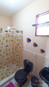 a bathroom with a toilet and a shower curtain at Casa temporada na praia Joia do Atlântico - Ilhéus - Ba in Ilhéus