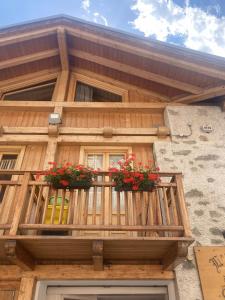 un bâtiment en bois avec deux boîtes de fleurs sur un balcon dans l'établissement Appartamento Eleonora, à Vermiglio