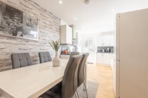 a kitchen and dining room with a white table and chairs at Bright, fresh, renovated 3 bedroom apartment in the heart of Montrose in Angus
