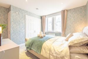 um quarto com uma cama com papel de parede azul e branco em Bright, fresh, renovated 3 bedroom apartment in the heart of Montrose em Angus