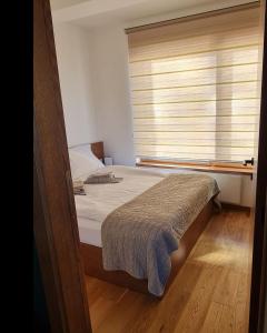 a bedroom with a bed and a window with blinds at Avram in Zlatibor