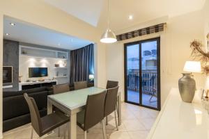 a dining room and living room with a table and chairs at Spacious 3BR APT in Prime Location of St Julians by 360 Estates in Tal-Għoqod