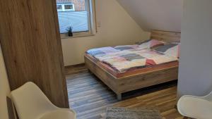 ein Schlafzimmer mit einem Bett und zwei weißen Stühlen in der Unterkunft Ostfriesland für Familie und Haustier in Uplengen
