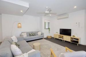 a living room with a couch and a tv at Unit 2 - Manly Boutique Apartments in Brisbane