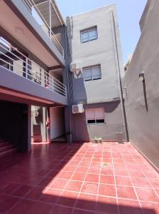 Urquiza Suites Salta في سالتا: مبنى به أرضية بلاط حمراء بجوار مبنى