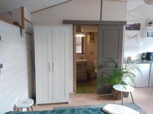 a kitchen with a white door and a table and stool at Studio 2 personnes Bannalec in Bannalec