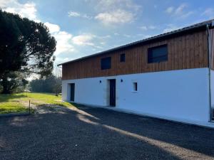 een groot wit gebouw met een grote garage bij Grange Luxe rénovée plein centre in Arsac