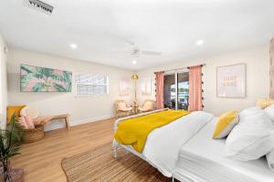 a bedroom with a bed with a yellow blanket at Luxury Villa 3 Blocks from the Beach with Hot Tub a Fire Pit and Outdoor Oasis in Cape Canaveral