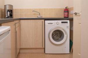 a washing machine in a kitchen with a sink at River View in Ingleton