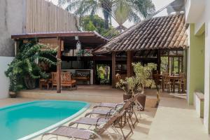 un patio con piscina y sillas y un restaurante en Pousada Maria Farinha, en Itacaré