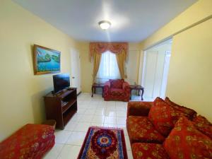 sala de estar con sofá y TV en Russell Heights Vacation Home, en Kingston