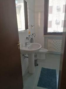 a bathroom with a sink and a toilet and a window at Casa Laghetto in Castellaro