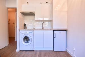 a kitchen with a washing machine and a sink at Les Hibiscus in Saint-Mandrier-sur-Mer