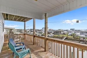 a porch with two chairs and a view of the ocean at Life of Sea-Renity 112 Burlington Street home in Holden Beach