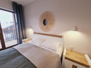 a bedroom with a bed and a mirror on the wall at Apartament E5 Karpatia - 5D Apartamenty in Karpacz