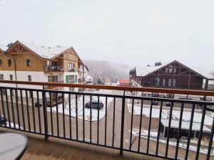 a balcony with a view of a snow covered yard at Apartament E5 Karpatia - 5D Apartamenty in Karpacz