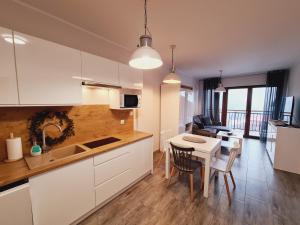 a kitchen and living room with a table and chairs at Apartament E5 Karpatia - 5D Apartamenty in Karpacz