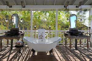 a bathroom with a bath tub and two mirrors at Belle Mont Sanctuary Resort - Kittitian Hill in Ortons