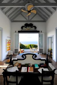 een woonkamer met een tafel en een plafondventilator bij Belle Mont Sanctuary Resort - Kittitian Hill in Ortons