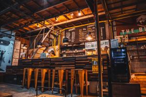 a restaurant with a bar with a bunch of chairs at Warehouse Hostel Koh Tao in Koh Tao