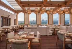 a restaurant with tables and chairs and windows at Mondrian Los Angeles in West Hollywood in Los Angeles