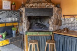 a kitchen with a stone oven with two stools at Mini kamp Perla in Prvić Luka