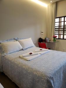 1 dormitorio con 1 cama con toallas en Pousada Cateto - Zona Rural, en Capitólio
