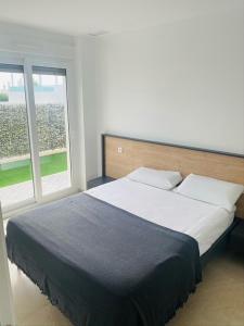 1 dormitorio con 1 cama grande y 2 ventanas en vistabella golf maui en Alicante