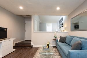 ein Wohnzimmer mit einem blauen Sofa und einem TV in der Unterkunft Executive Studio Jr One Bedroom with Balcony and Pool in Los Angeles