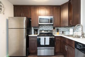 a kitchen with wooden cabinets and stainless steel appliances at Executive Studio Jr One Bedroom with Balcony and Pool in Los Angeles