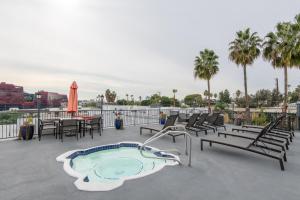 eine Terrasse mit einem Pool mit Stühlen und einem Tisch in der Unterkunft Executive Studio Jr One Bedroom with Balcony and Pool in Los Angeles