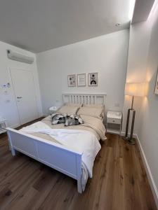 um quarto branco com uma cama e piso em madeira em Cozy Living Bergamo em Seriate