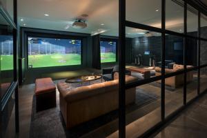 a living room with a couch and a view of a baseball game at Four Seasons Hotel Houston in Houston