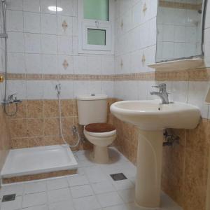 uma casa de banho com um WC e um lavatório em A Home Away From Home em Abu Dhabi